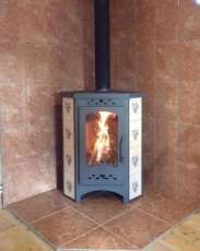 Недорогая печь-камин Бавария угловая с плитой незабудка Амазонка бай фото в интерьере в Барановичах